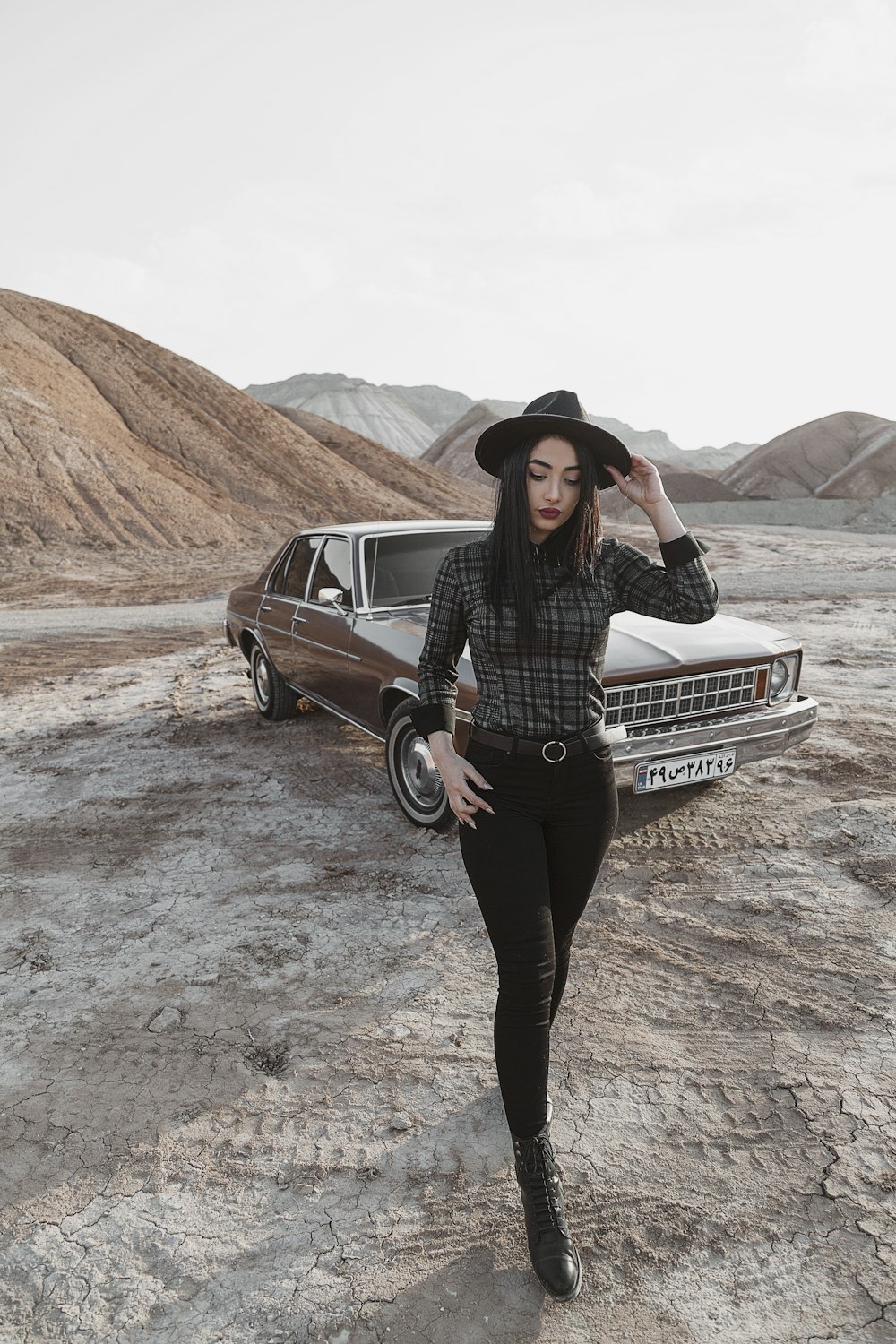 woman in black long sleeve shirt and black pants standing beside black mercedes benz car