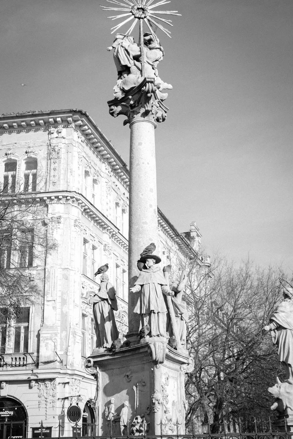grayscale photo of man and woman statue near building
