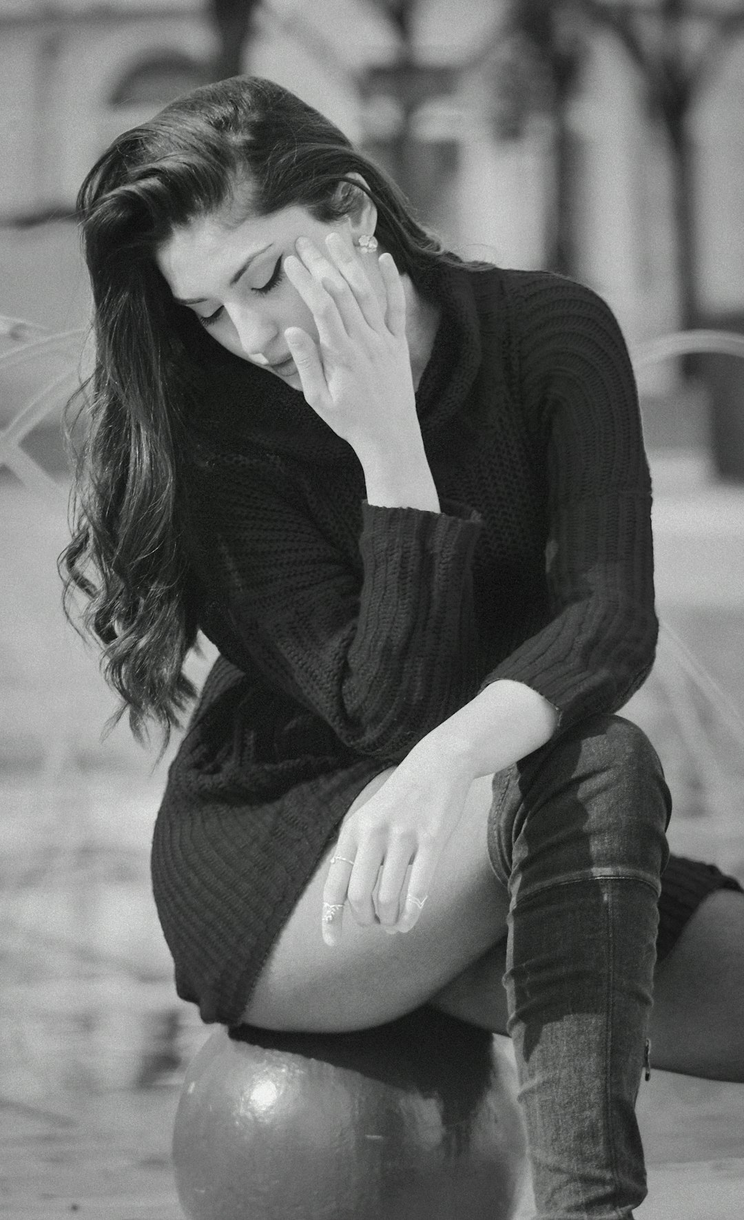 woman in black long sleeve shirt and black and white striped skirt sitting on floor