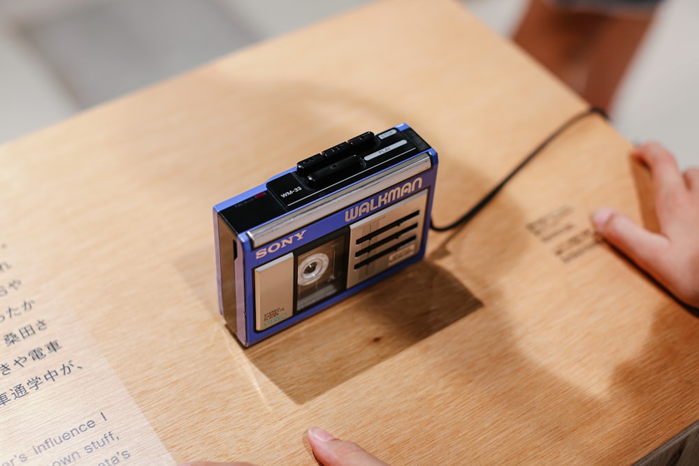 blue and black electronic device on brown wooden table