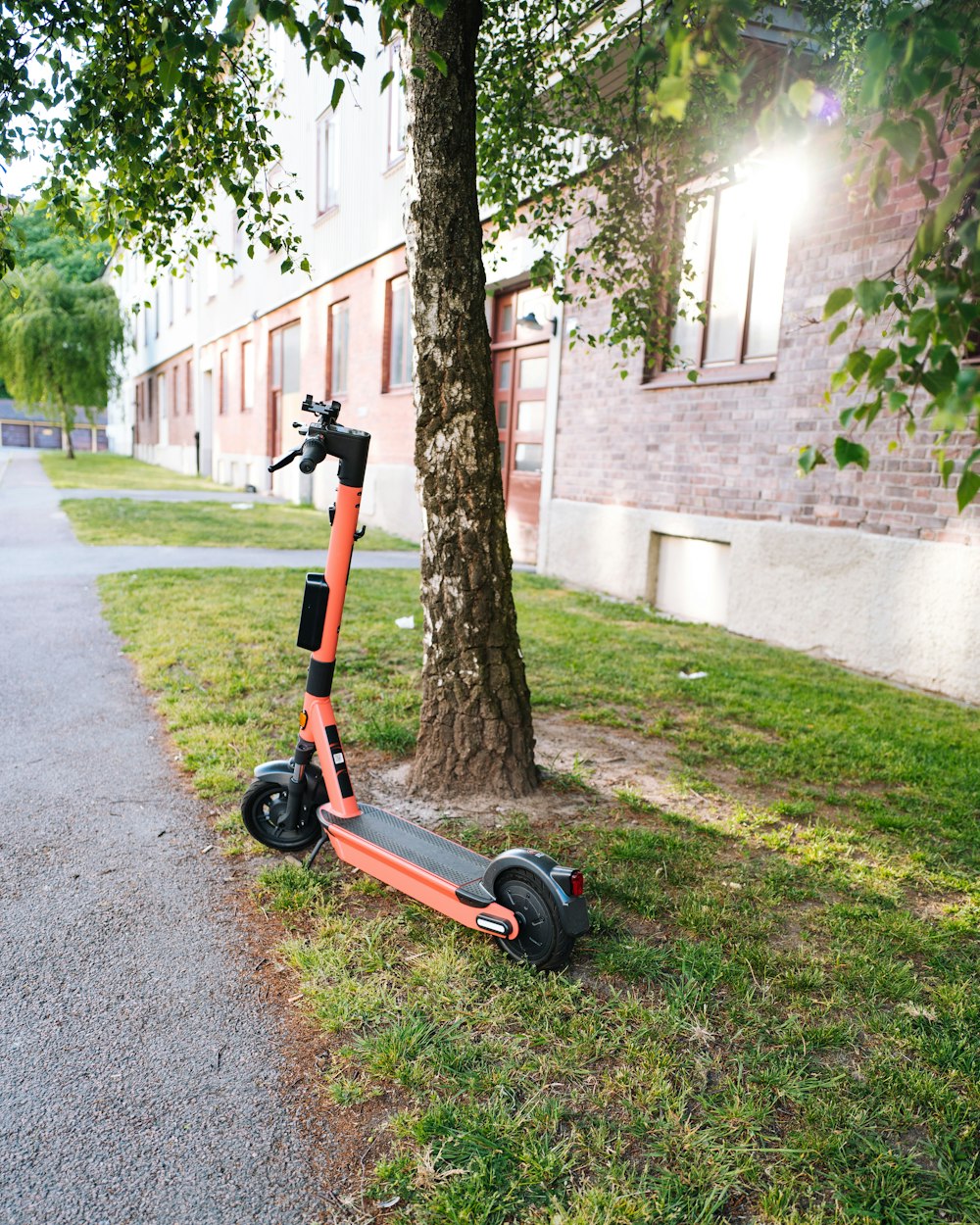 red and black kick scooter on road during daytime