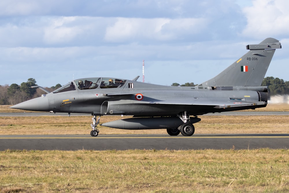 black jet plane on brown field under white clouds during daytime