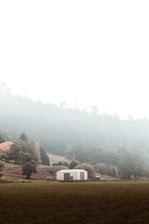 A serene view of a rural school building surrounded by greenery.