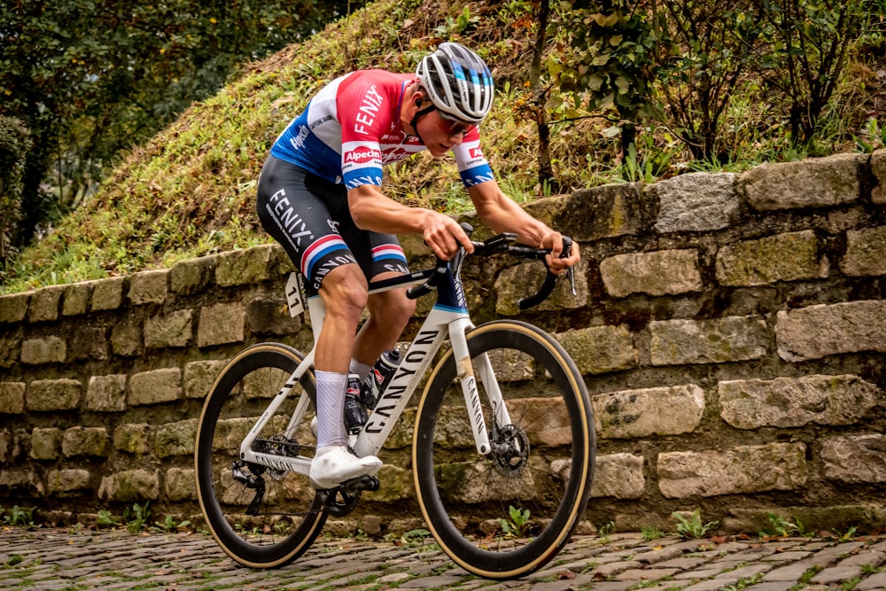 man in red and blue shirt riding on white and black bicycle