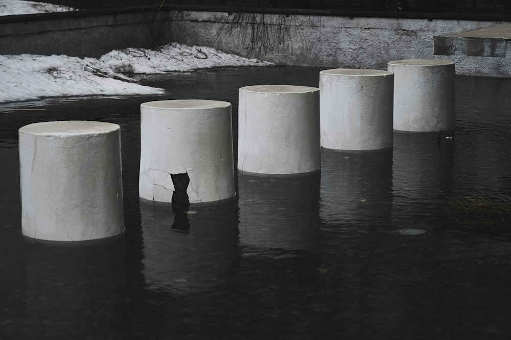 personne en veste noire et pantalon noir debout sur un rocher gris près d’un plan d’eau pendant