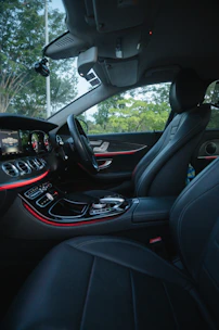 Luxury black car interior with leather seats and ambient lighting.