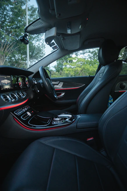 The elegant interior of a chauffeur-driven car showing plush leather seats and ambient lighting