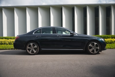 black sedan parked near white building