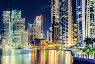 city skyline near body of water during night time