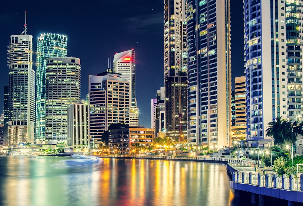 city skyline near body of water during night time