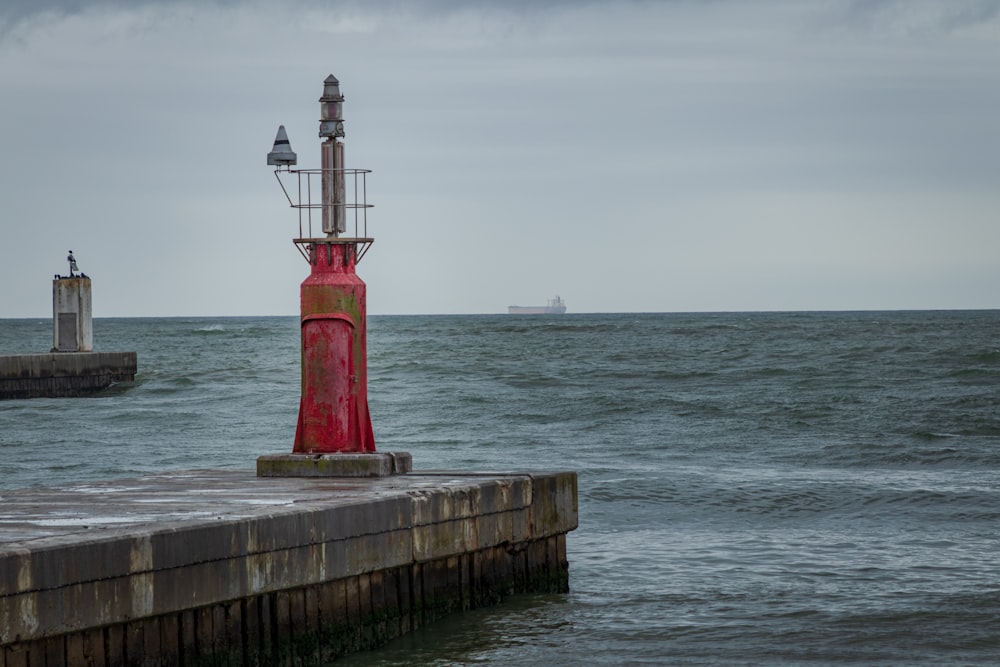 red and white lighthouse near body of water during daytime