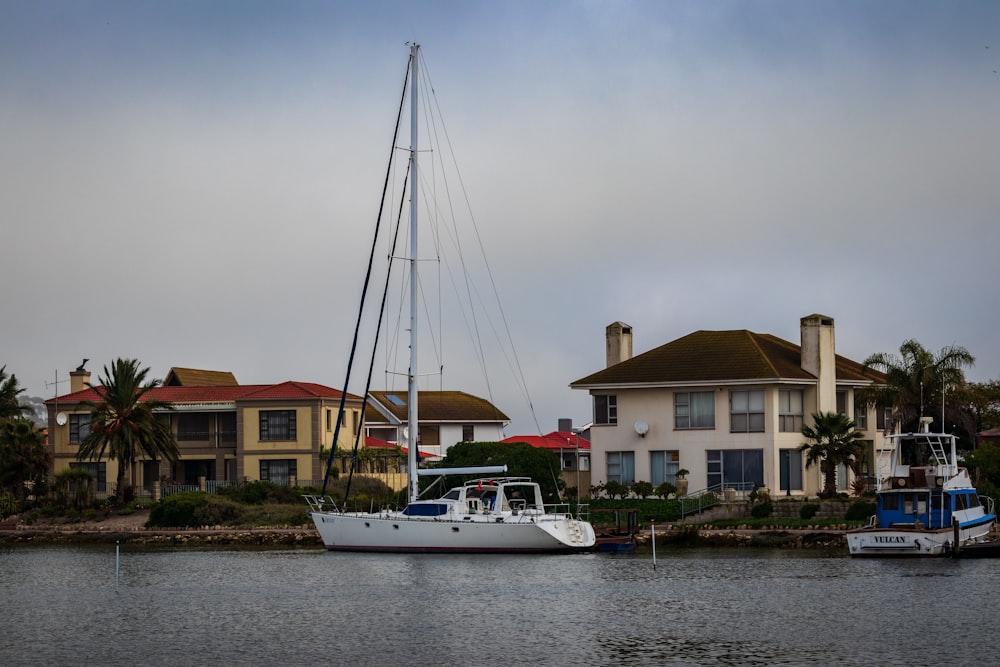 white boat on body of water near brown and white concrete building during daytime