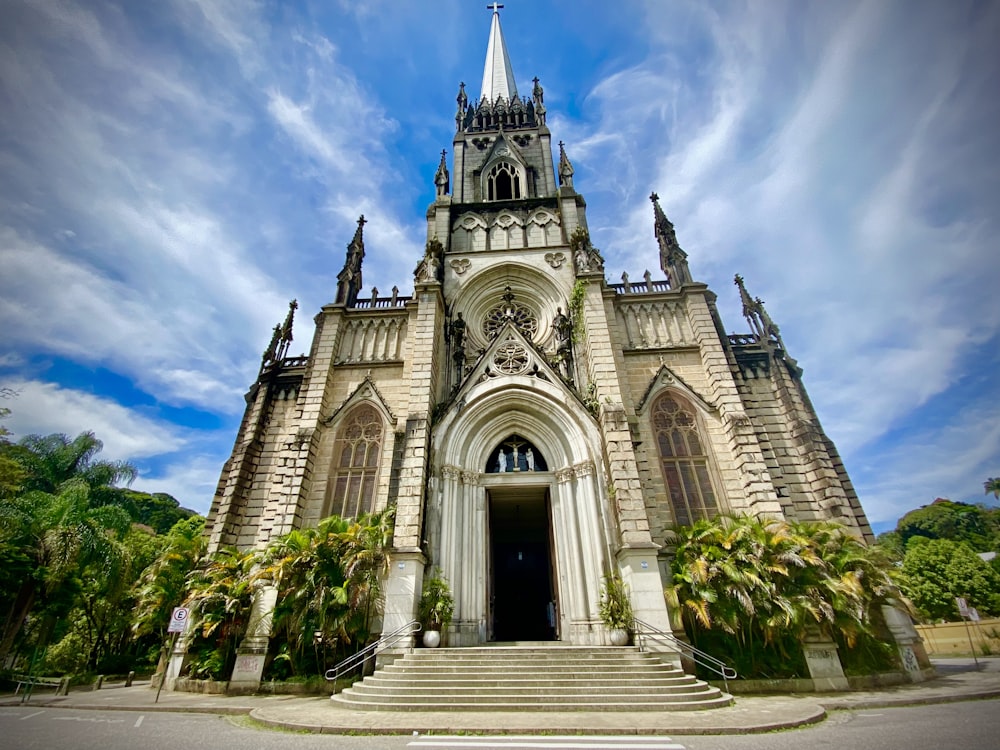 white and brown concrete church under white clouds and blue sky during daytime