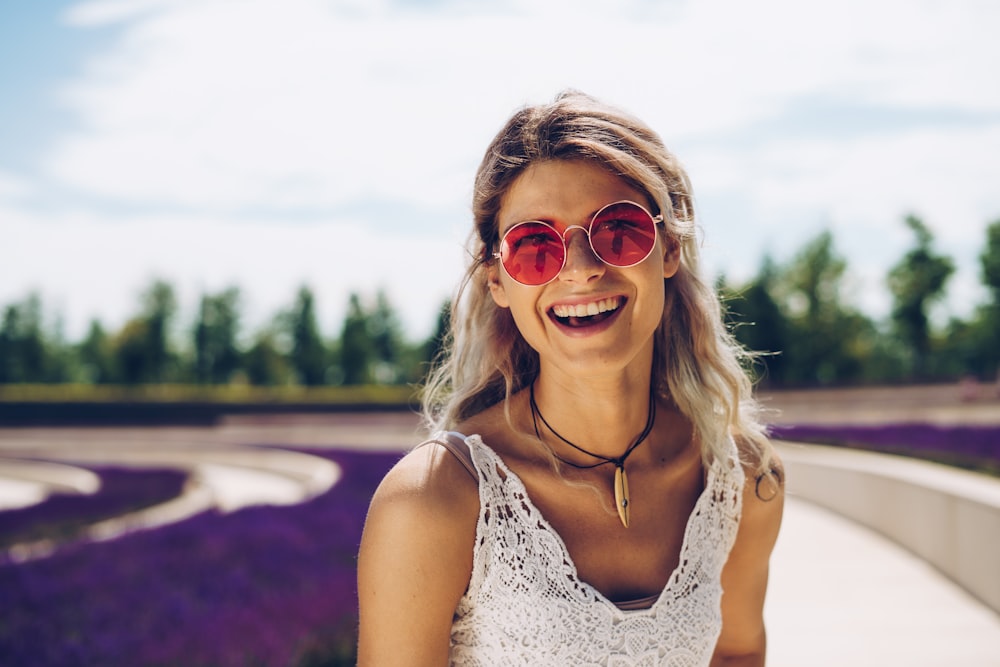 Frau in weißem geblümtem Tanktop mit Sonnenbrille