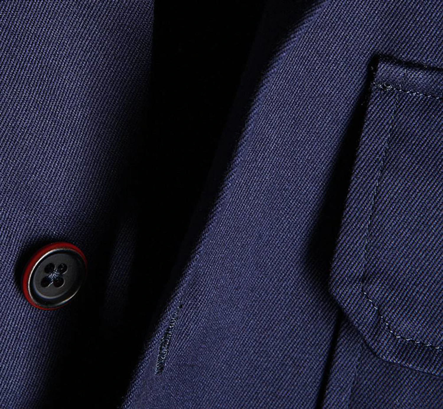 The Thornleigh overcoat laid flat, showing its navy melton flap pocket and oxblood horn button