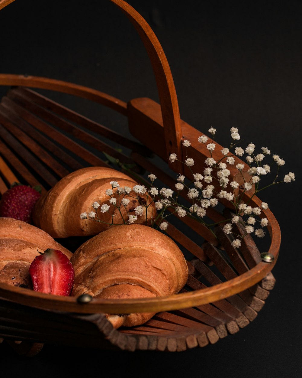 corbeille en bois marron avec des fruits ronds rouges et bruns