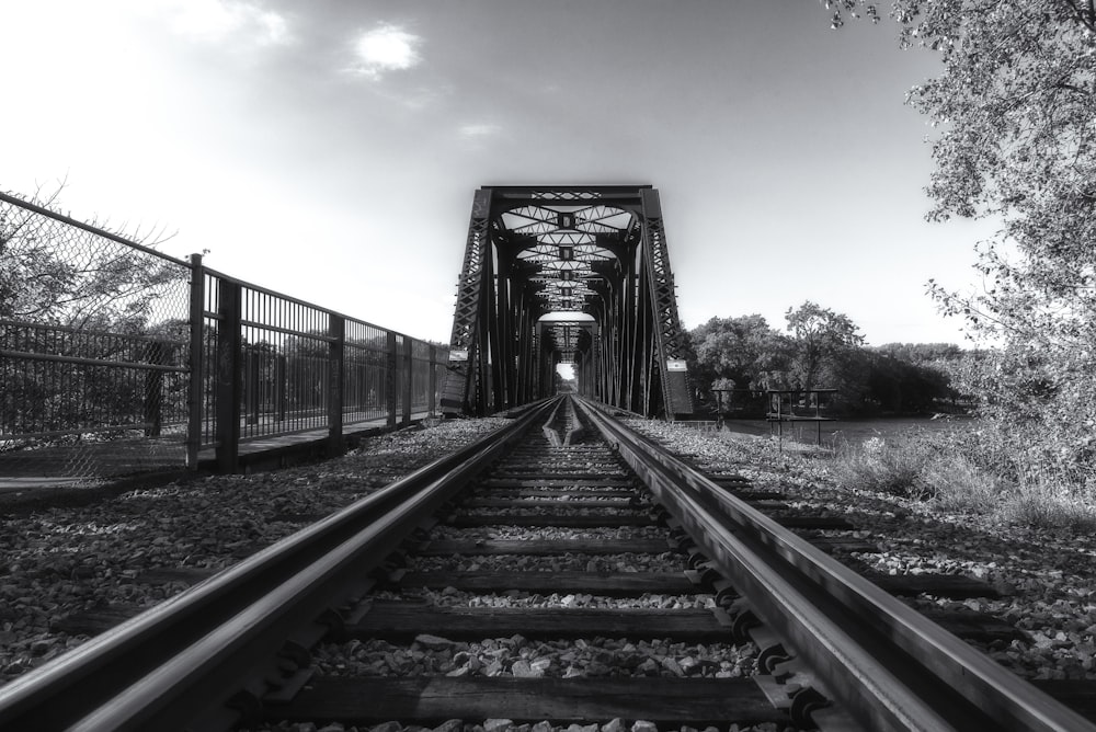 train rail under cloudy sky during daytime