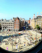 Panoramic 360-degree view of a historic city square with people walking around.