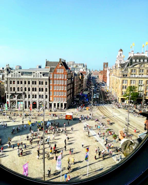 Panoramic 360-degree view of a historic city square with people walking around.