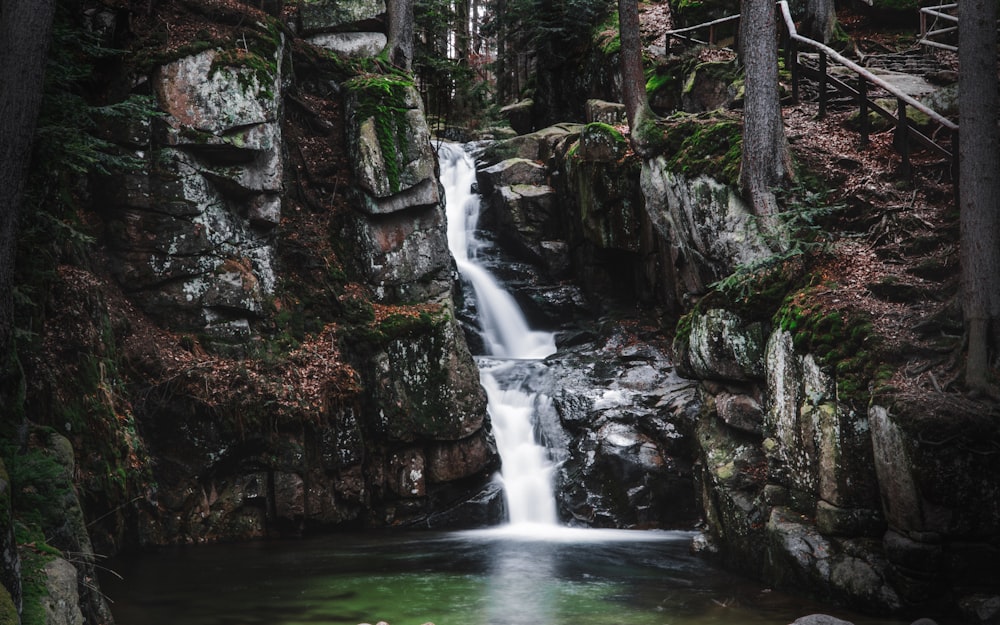 water falls between brown rocks