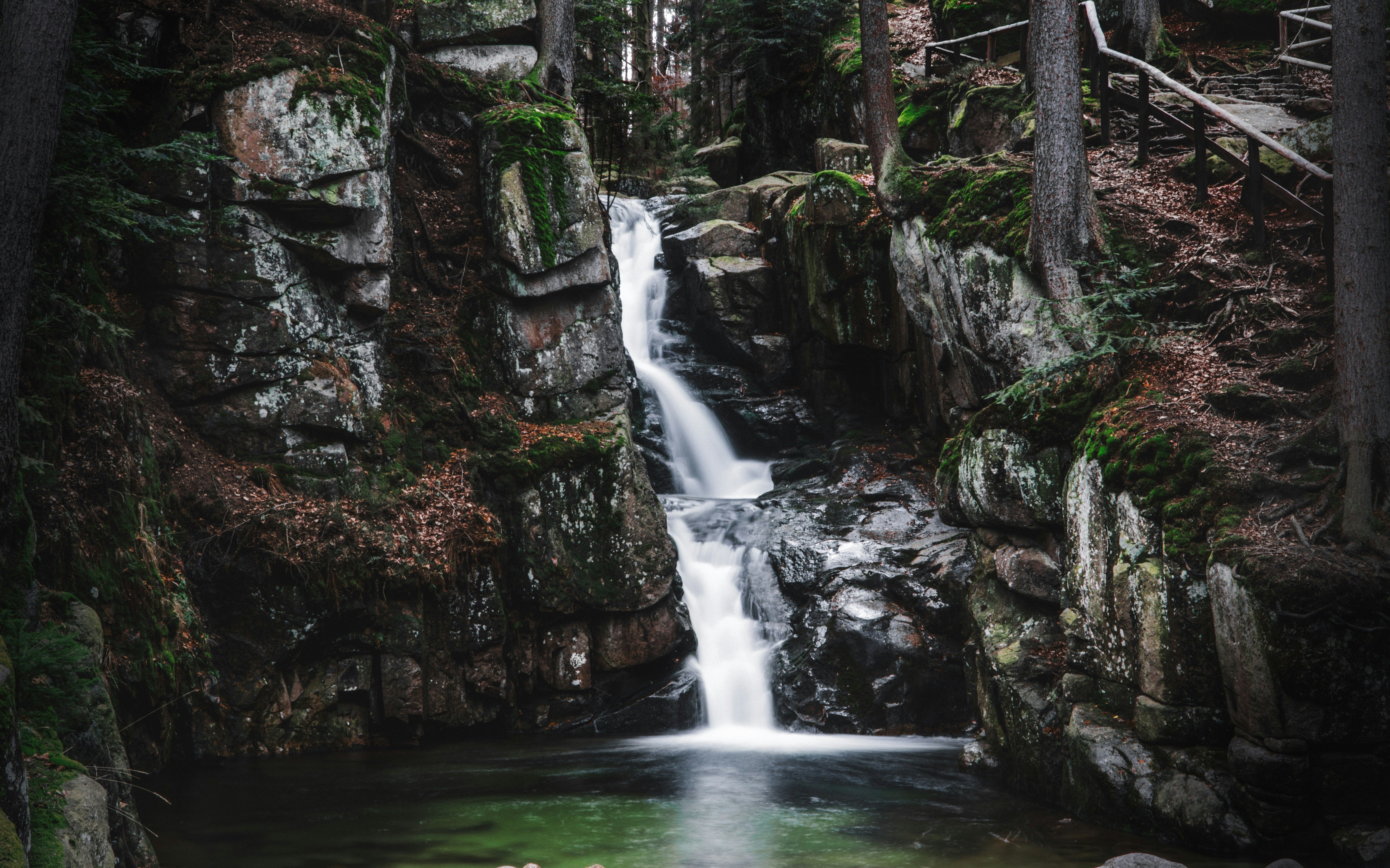 water falls between brown rocks