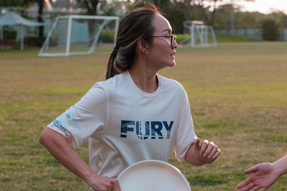 woman in white crew neck t-shirt holding white round plate during daytime