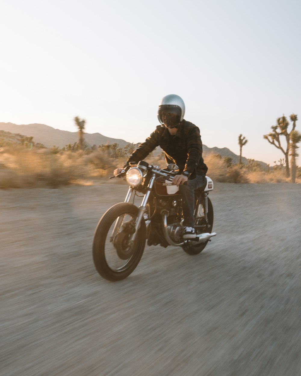 man in black jacket riding motorcycle on road during daytime