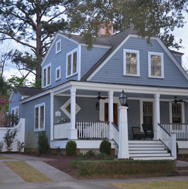 white and blue wooden house near green trees during daytime