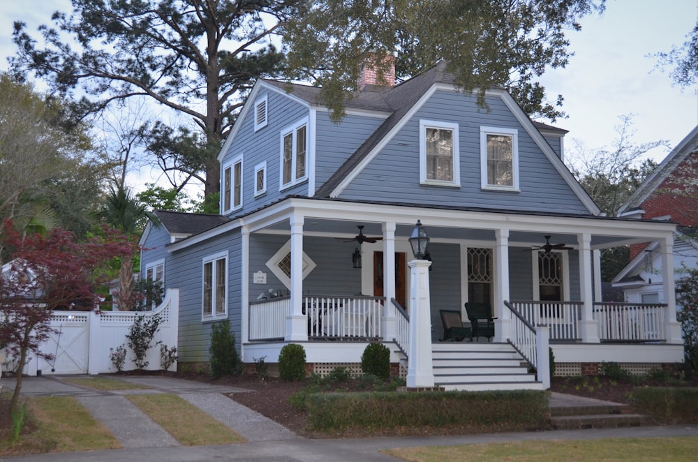 white and blue wooden house near green trees during daytime