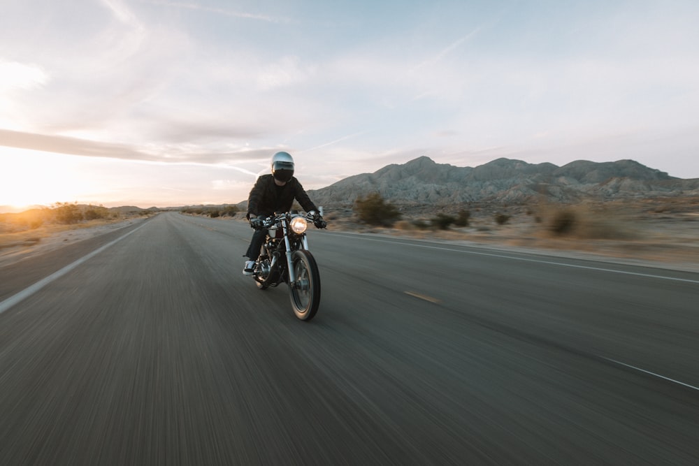 man riding motorcycle on road during daytime