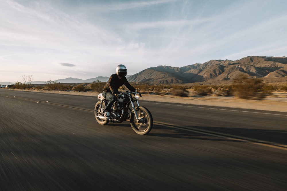 man riding motorcycle on road during daytime