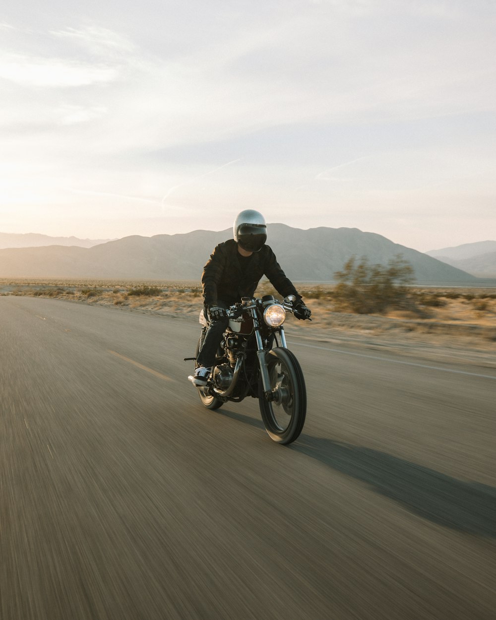 Hombre que monta motocicleta en la carretera durante el día