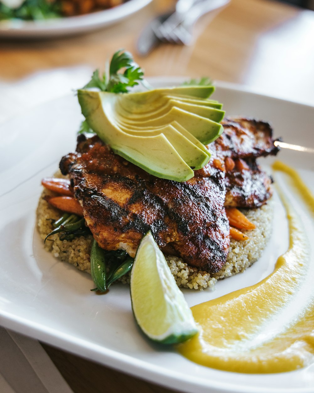 grilled meat with green leaf on white ceramic plate