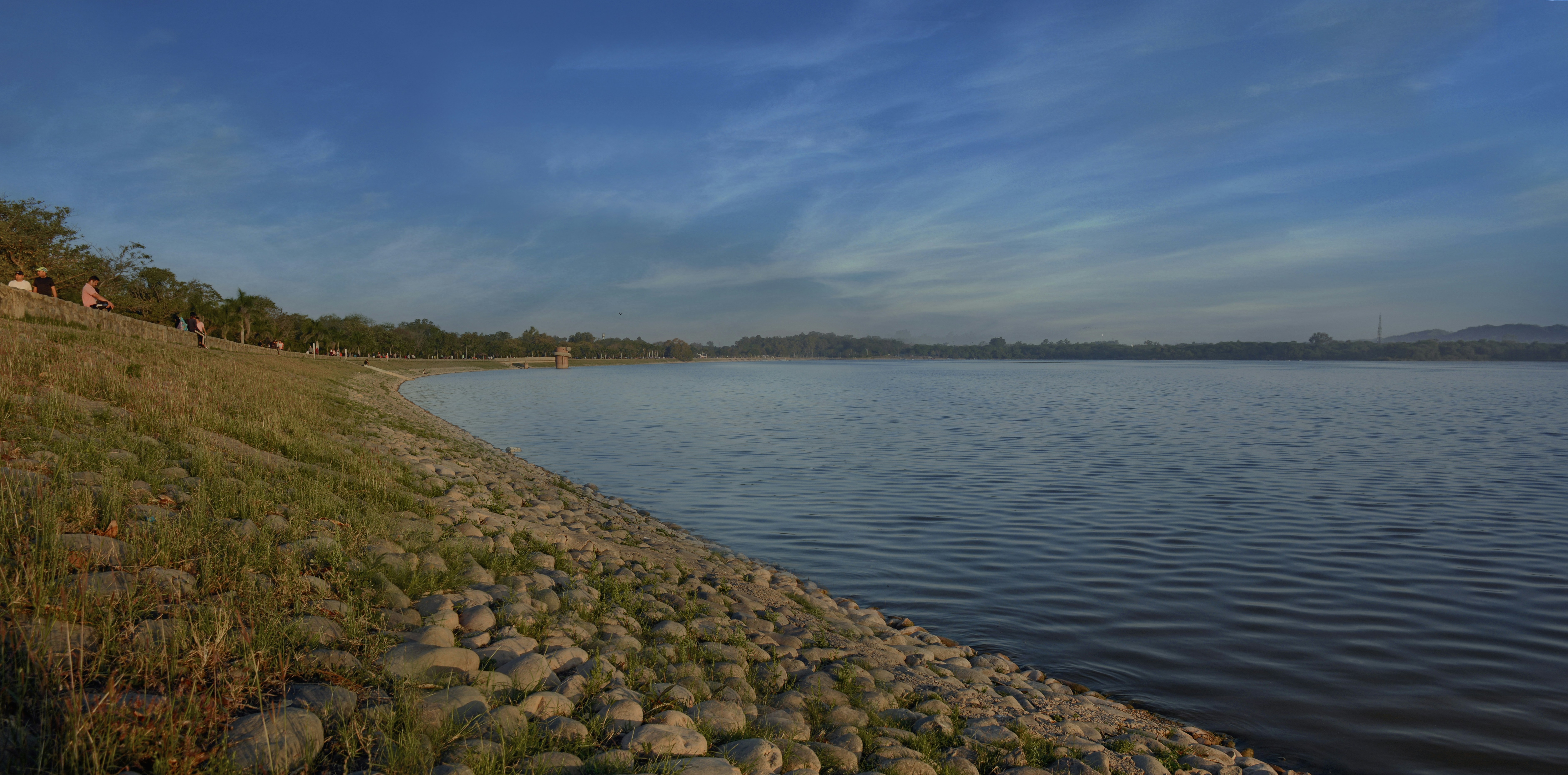 gray rocks beside body of water under blue sky during daytime