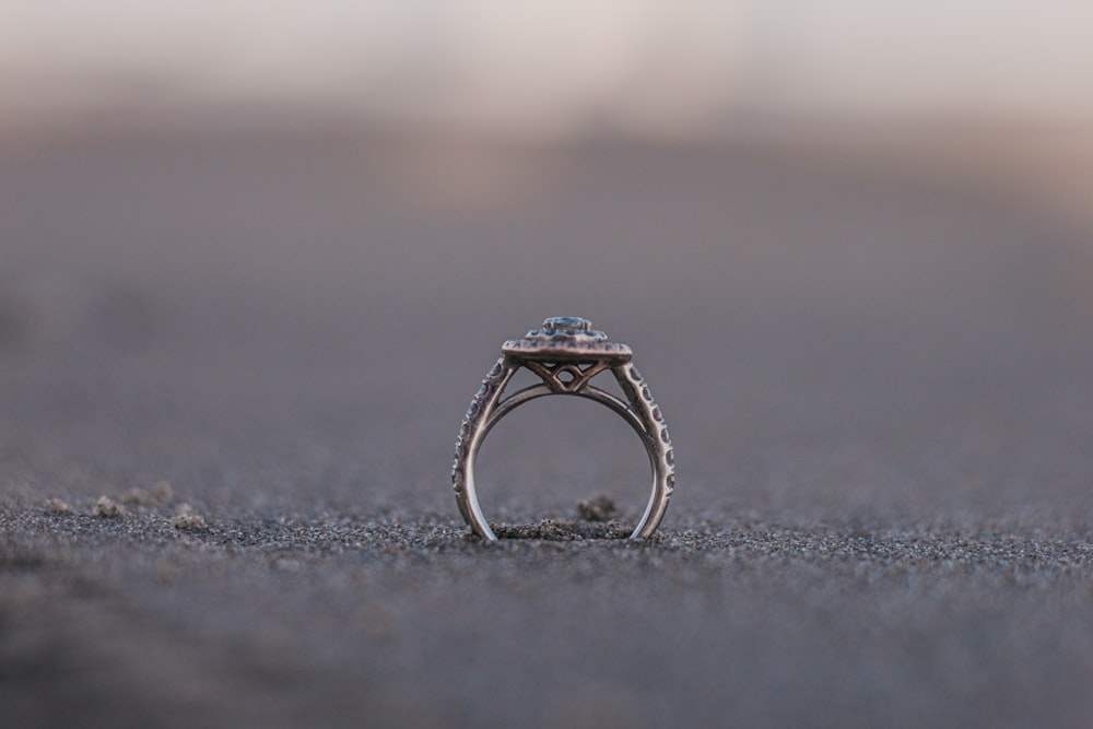 silver diamond ring on gray sand