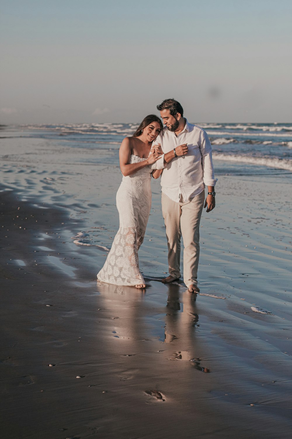 man and woman kissing on beach during daytime