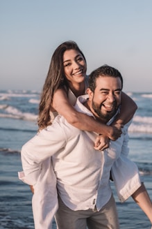 man in white dress shirt hugging woman in white dress