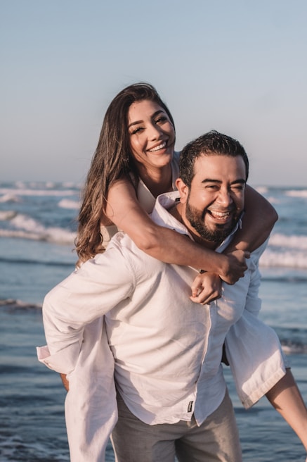 man in white dress shirt hugging woman in white dress