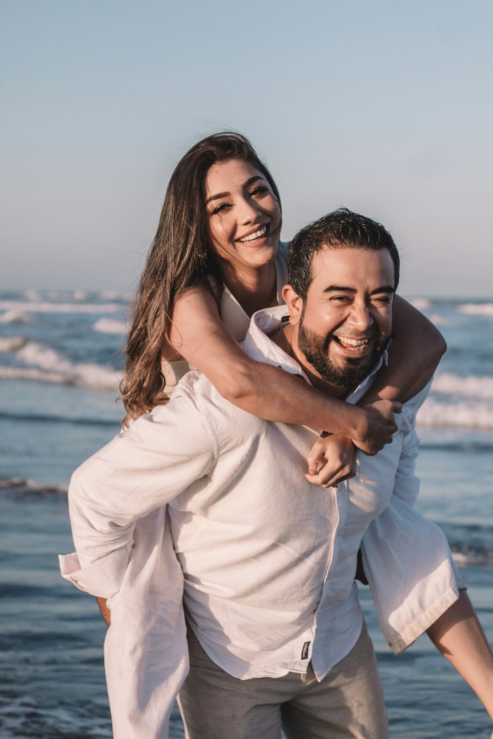 man in white dress shirt hugging woman in white dress