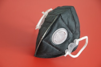 Close-up of a high-quality fire mask with clear filters, set against a navy blue background.