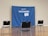 A blue banner with the word 'VACCINATED!' and a message encouraging COVID-19 vaccination is set up as a backdrop. It is surrounded by three black and gray chairs on a polished wooden floor in an empty room.