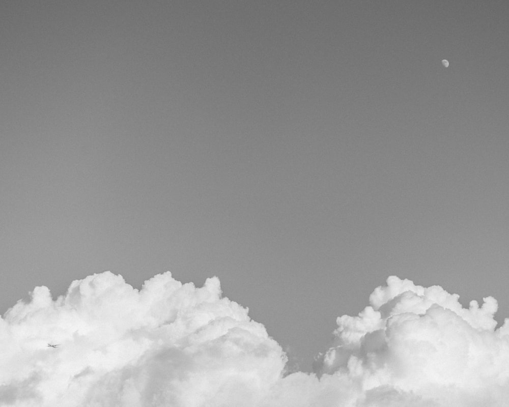 white clouds and moon in grayscale photography