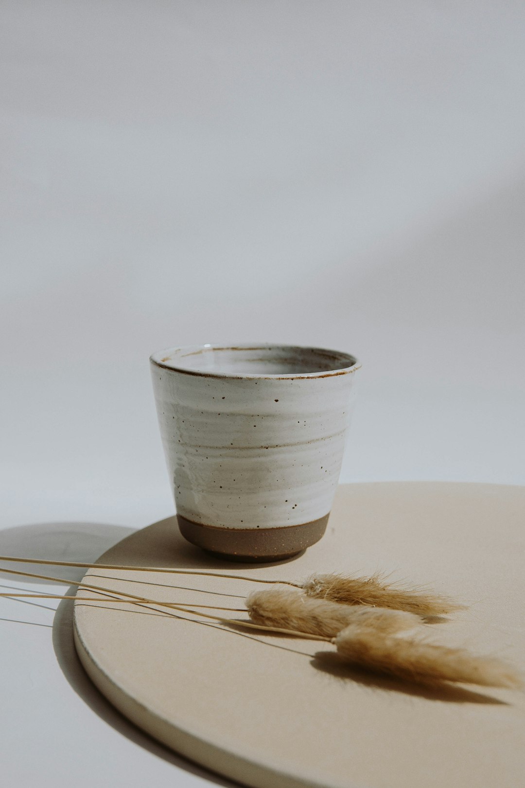 white and silver cup on brown wooden table