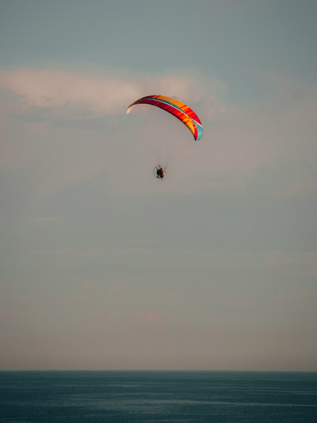 person in parachute under white clouds during daytime