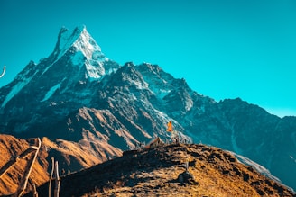 person standing on rock near snow covered mountain during daytime