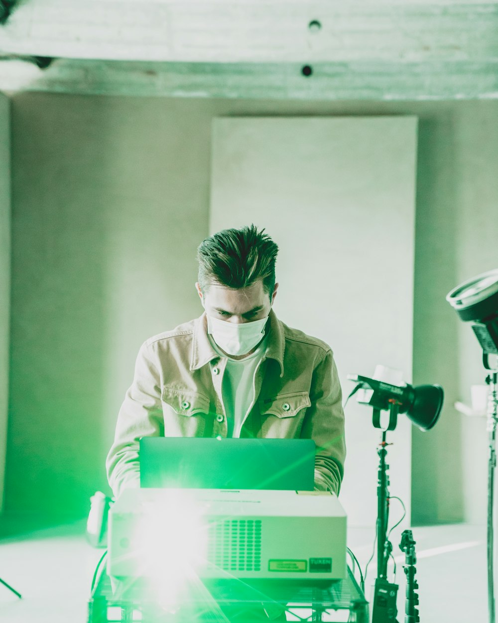 man in white dress shirt holding green and white power tool