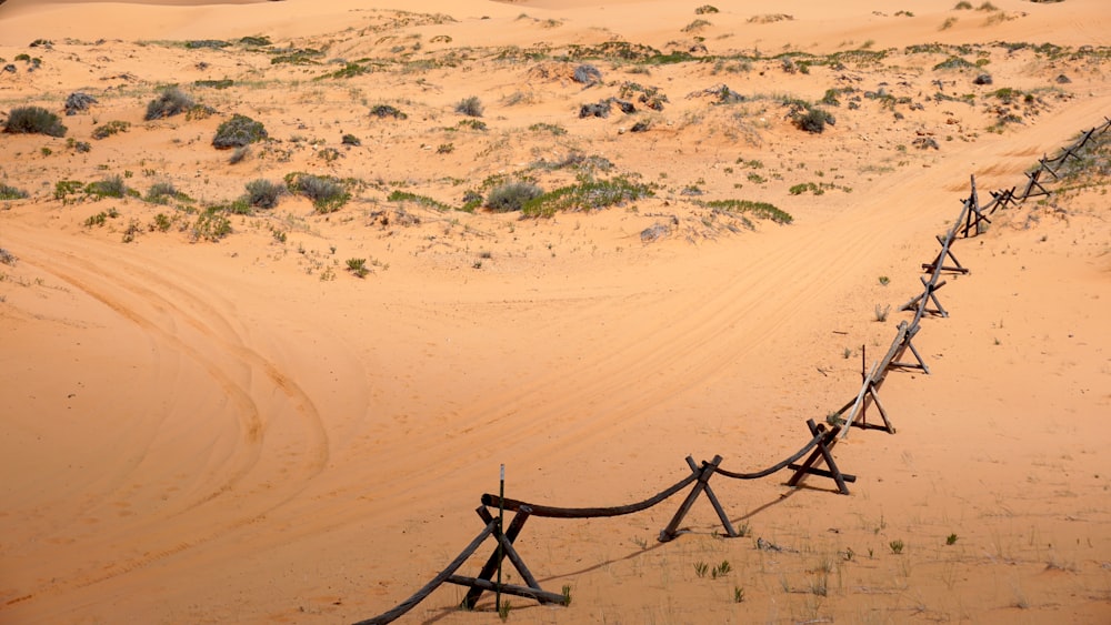 Schwarzer Metallzaun auf braunem Sand