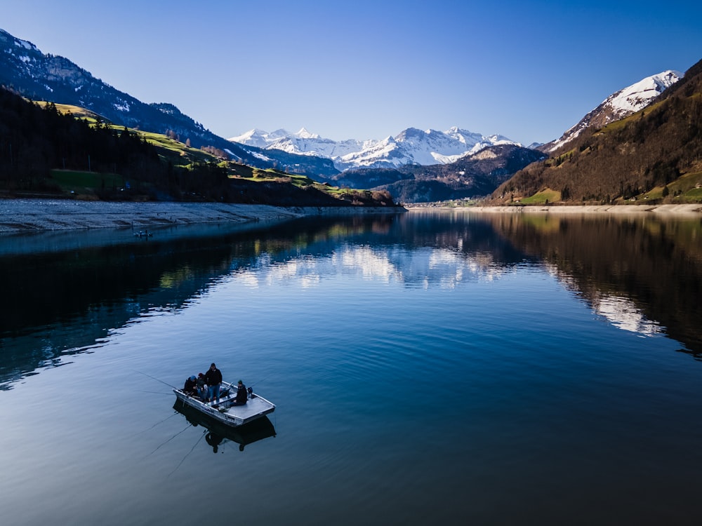 person sitting on boat on lake during daytime