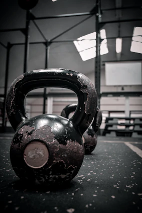 A sleek kettlebell resting on a gym floor with soft morning light