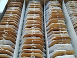 Rows of tea bags are neatly arranged in a box, each labeled with a tag attached by a string. The tea bags are aligned in an orderly fashion, revealing a brown and white color scheme.